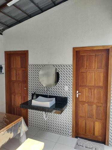 ein Raum mit einem Waschbecken und einem Spiegel an der Wand in der Unterkunft Hospedagem da vila in Santa Teresa