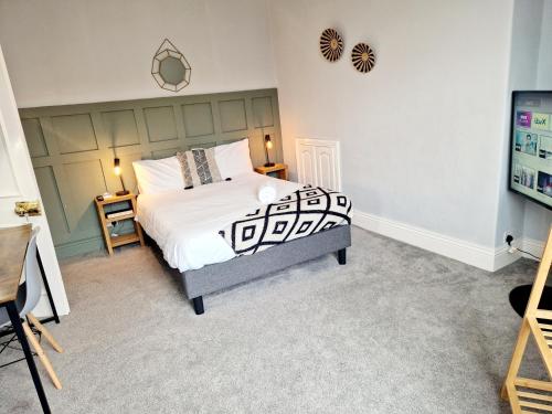 a bedroom with a bed with a black and white comforter at West Beck House Newcastle - Spacious Double Room in North Shields