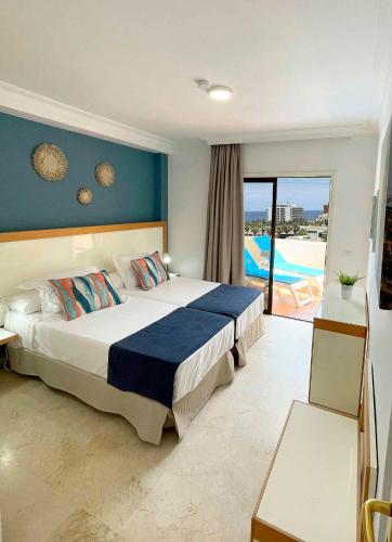a bedroom with a bed with a view of a pool at Apartamentos Bahia Playa in Puerto de la Cruz