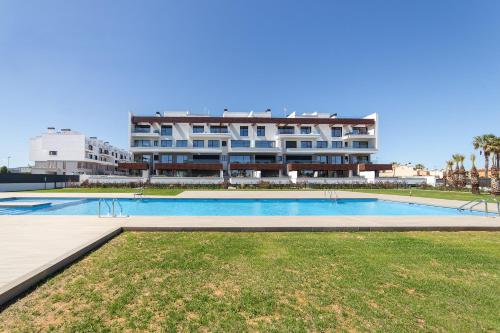 a swimming pool in front of a large building at Oceans Oliva in Oliva