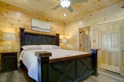 a bedroom with a large bed in a wooden room at NEW BUILD-5BD-Hottub-WIFI-Theater-Pool Tble-ROKU in Pigeon Forge