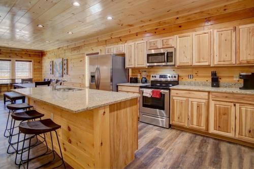 a large kitchen with wooden cabinets and a counter top at NEW BUILD-5BD-Hottub-WIFI-Theater-Pool Tble-ROKU in Pigeon Forge
