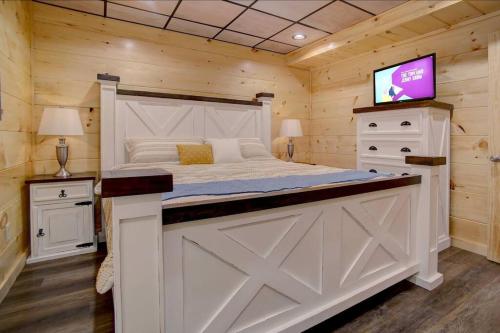 a bedroom with a bed and a tv in it at NEW BUILD-5BD-Hottub-WIFI-Theater-Pool Tble-ROKU in Pigeon Forge