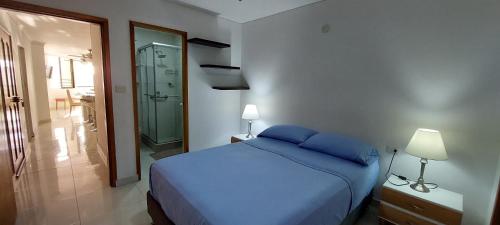 RodaderoにあるMar & Sierra El Rodadero Apto Vista al Mar Piscina & Playaのベッドルーム(青いベッド1台付)、バスルーム