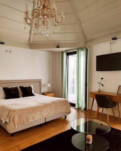 a bedroom with a bed and a table and a chandelier at Douro Village in Vila Real