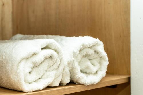 a pile of white towels sitting on a wooden shelf at Puesta del Sol Guest House in San Andrés