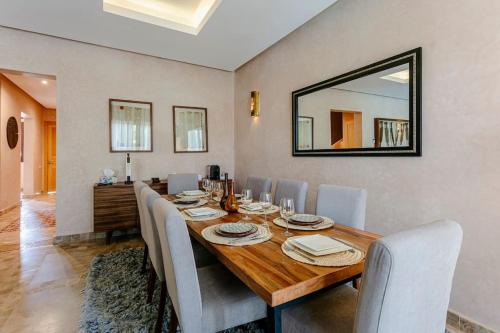 a dining room with a table with chairs and a mirror at Villa Atlas Harmony Marrakech in Marrakech