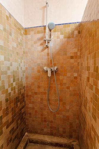 a shower with a hose in a tiled bathroom at Villa Atlas Harmony Marrakech in Marrakech