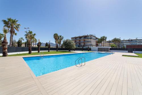 a swimming pool in a building with palm trees at Oceans Oliva in Oliva