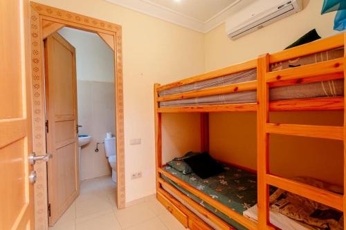 a bedroom with two bunk beds and a bathroom at Villa Atlas Harmony Marrakech in Marrakech