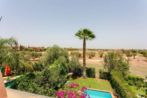 a resort with a palm tree and a swimming pool at Villa Atlas Harmony Marrakech in Marrakech