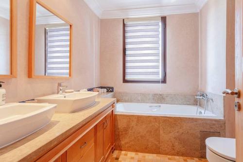 a bathroom with two sinks and a tub at Villa Atlas Harmony Marrakech in Marrakech