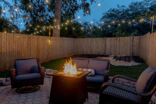 a backyard with a fire pit and two chairs and a fence at Quiet, convenient & Modern Haven in Gainesville