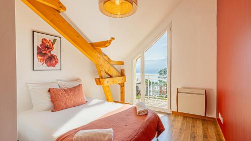 a bedroom with a bed and a large window at Villa Panoramique - Lac du Bourget in Bourdeau