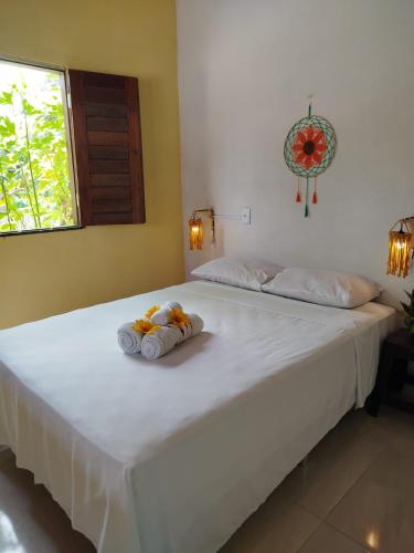 a large white bed with two stuffed animals on it at Villa dos Coqueirais in Icaraí