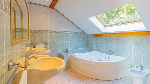 a bathroom with two sinks and a tub and a toilet at Villa Panoramique - Lac du Bourget in Bourdeau