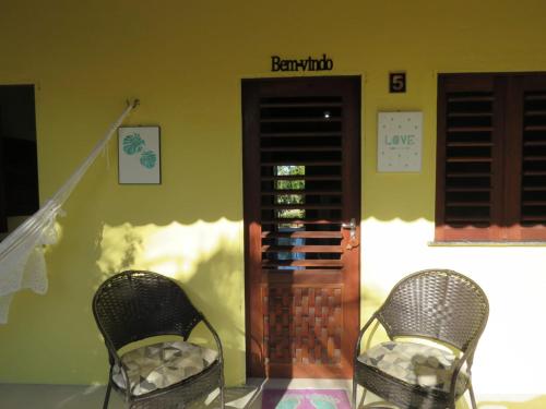 two chairs sitting in front of a building at Villa dos Coqueirais in Icaraí