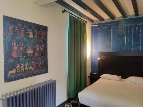 a bedroom with a bed and a painting on the wall at KolMojen in Sint-Truiden