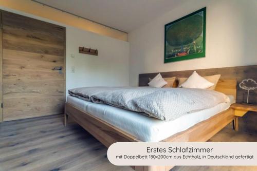 a bedroom with a large bed with a wooden door at INVITA Natur-Chalets - Familienurlaub im Schwarzwald in Bad Dürrheim