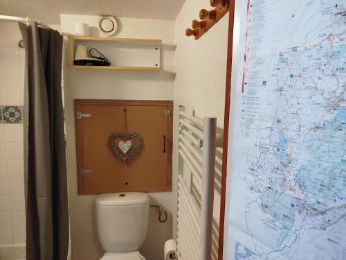 La salle de bains est pourvue de toilettes et d'une carte murale. dans l'établissement Studio chaleureux et cosy, à Valfréjus