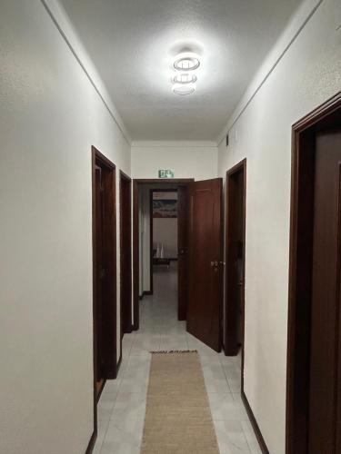 a hallway with brown doors and a tile floor at Apartamento F.A in Pedrógão