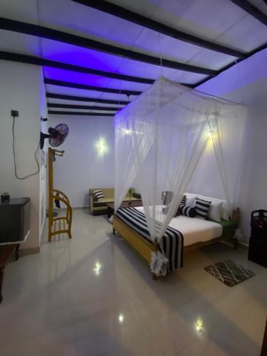 a bedroom with a bed with a mosquito net at Cozy Homestay Waterfall Road Ella in Ella