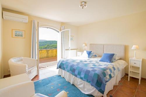 une chambre avec un lit et une porte ouverte dans l'établissement Villa Les Etoiles by Villa Plus, à Lorgues