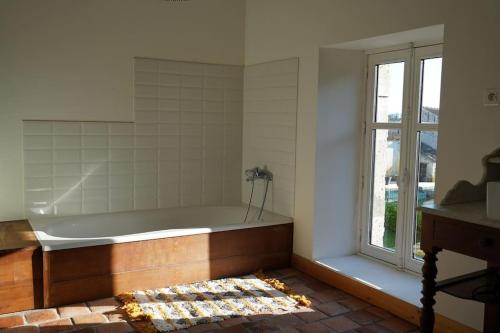 une baignoire dans une pièce avec une fenêtre dans l'établissement Logis de la Clé des Champs Immense Piscine Calme verdoyant, à Jurignac