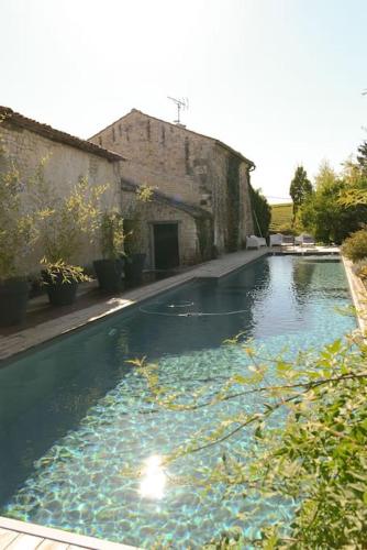 - une piscine d'eau bleue dans un ancien bâtiment dans l'établissement Logis de la Clé des Champs Immense Piscine Calme verdoyant, à Jurignac