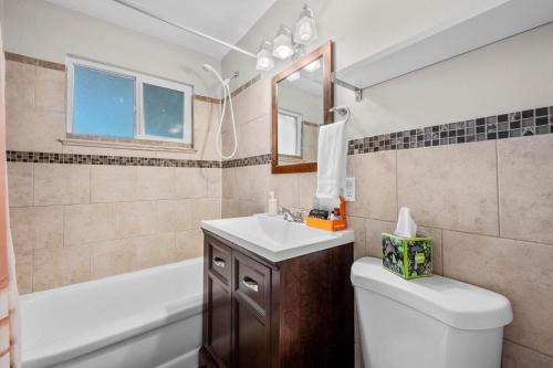 a bathroom with a sink and a toilet and a tub at 7290 W 10th Ave in Lakewood