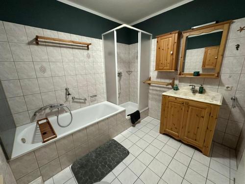 a bathroom with a tub and a sink at Hörselberg Apartment in Hörselberg-Hainich