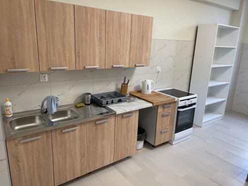 a kitchen with wooden cabinets and a sink and a stove at Hostel ELDORADO in Końskie