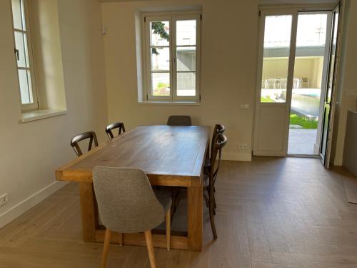 a wooden table and chairs in a room with windows at Espectacular casa en Salinas by BeBalmy in Salinas