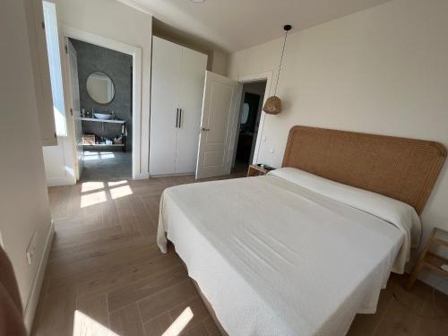 a bedroom with a white bed and a hallway at Espectacular casa en Salinas by BeBalmy in Salinas