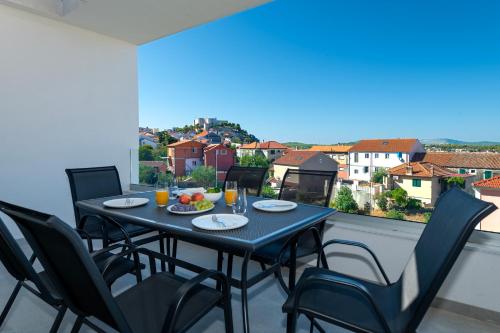 a table and chairs on a balcony with a view at Providenca Residence Šibenik in Šibenik