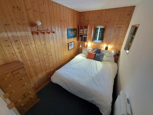 a bedroom with a bed in a room with wooden walls at Appartement Arcs 1800 Les Villards 5 personnes in Bourg-Saint-Maurice