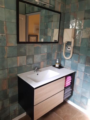 une salle de bain avec un lavabo et un miroir dans l'établissement La croisée des chemins, à Calvisson