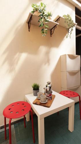 a table with two red chairs and a white table with flowers at Piazza Duomo - 20 min by train to Florence in Prato