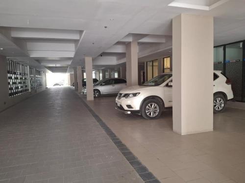 a parking lot with cars parked in a building at Elegant Secured Family Apartment with Open Space in Dhaka