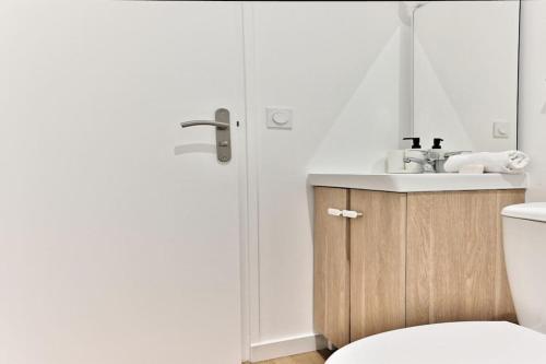 une salle de bain avec un lavabo et des toilettes dans l'établissement Appartement spacieux près de Paris - II, à Bagnolet