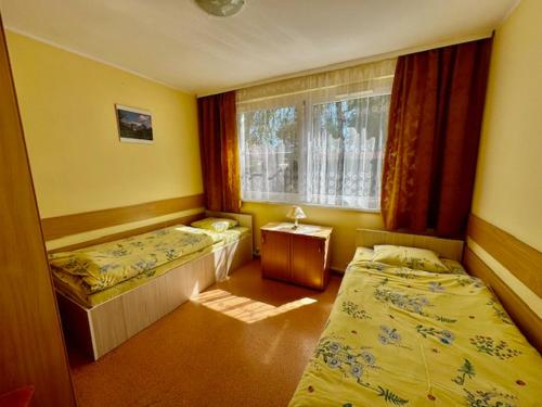 a room with two beds and a window at Ośrodek Wypoczynkowy Świerk in Niewiesze