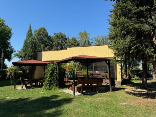 a pavilion with a table and benches in the grass at Ośrodek Wypoczynkowy Świerk in Niewiesze