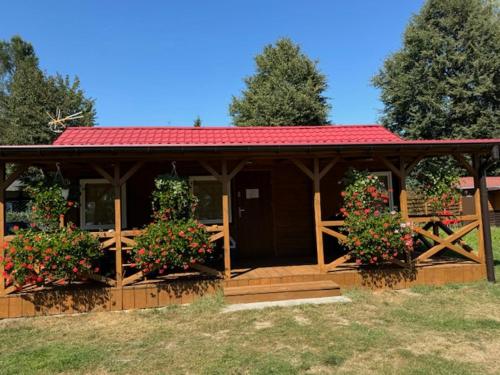 a wooden pavilion with two flowering plants on it at Ośrodek Wypoczynkowy Świerk in Niewiesze