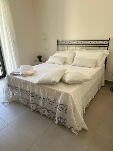a large white bed with white sheets and pillows at B&B Case Marcapane in Sommatino