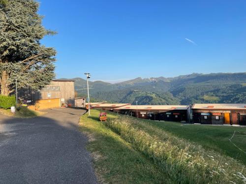 an empty road next to a building with mountains in the background at Le Joy - Murat le Quaire - 5 pers in Murat-le-Quaire