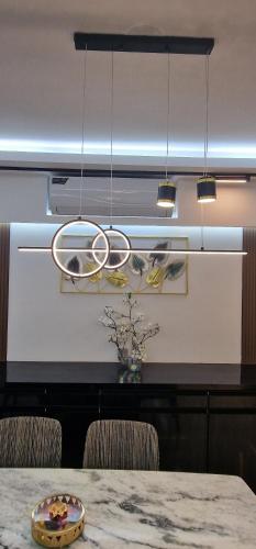 a dining room with a table and a chandelier at Elegant Secured Family Apartment with Open Space in Dhaka