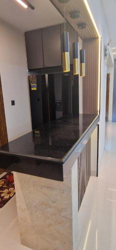 a kitchen with a black counter top in a room at Elegant Secured Family Apartment with Open Space in Dhaka