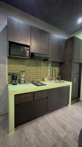 a kitchen with a counter with a sink and a microwave at Estudio Centrico Tulum in Tulum