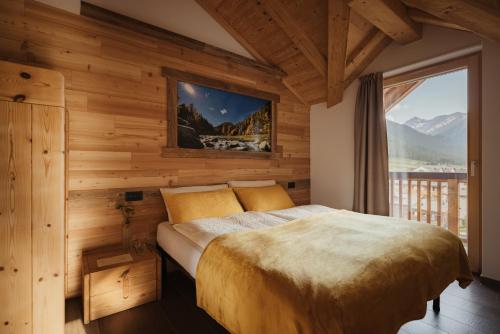a bedroom with a bed with a large window at Bonvivar -- Mountain Guesthouse in Livigno