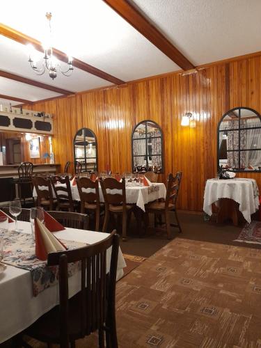 a dining room with tables and chairs and wooden walls at Rekreační středisko ROJANA in Svratka
